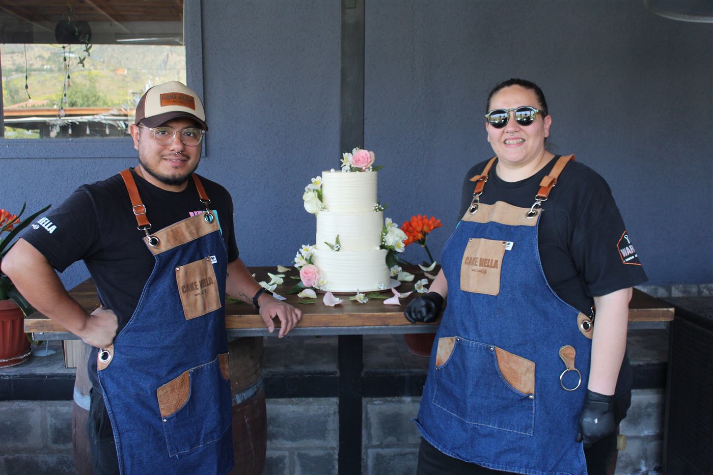 El equipo de Cake Nella junto a una torta de matrimonio